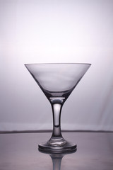 Transparent glass cup with a pouring bubbling cold fresh water with bubbles and drops
