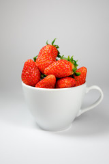 Strawberry in the white coffee cup on a white background
