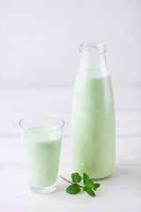 Milk cocktail with mint on a rustic white table