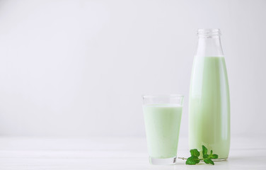 Milk cocktail with mint on a rustic white table