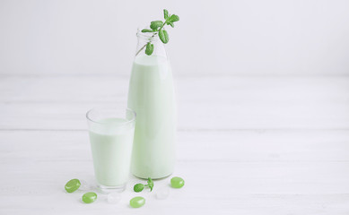 Milk cocktail with mint on a rustic white table