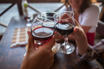 happy friends in a bar drinking red wine.