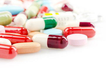 Pharmacy theme. Multicolored Isolated Pills and Capsules on the White Surface. Closeup