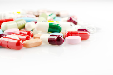 Pharmacy theme. Multicolored Isolated Pills and Capsules on the White Surface. Closeup