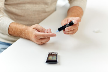 senior man with glucometer checking blood sugar