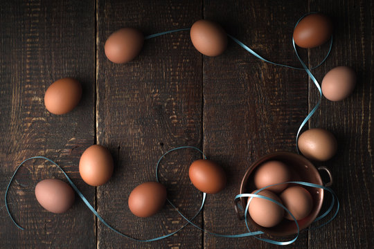 Chicken eggs with ribbons on the wooden table top view
