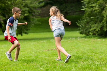 group of happy kids or friends playing outdoors