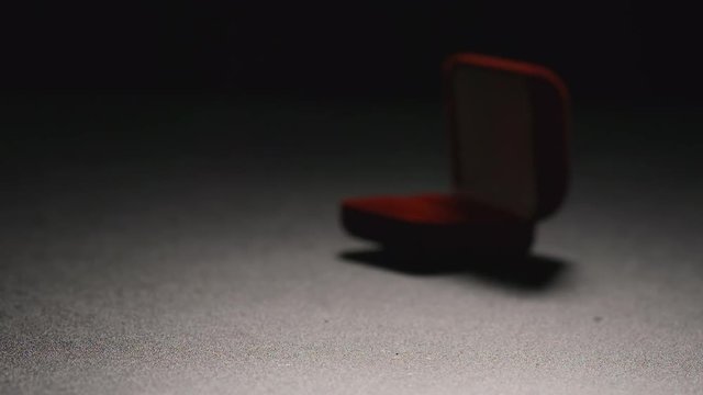 SLOW MOTION: Gift box with a golden ring fall on a floor