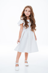 Full length of little girl in dress standing and posing