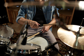 Fototapeta na wymiar male musician playing drums and cymbals at studio