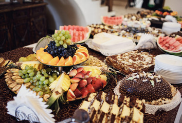 The buffet table with cakes and fruits