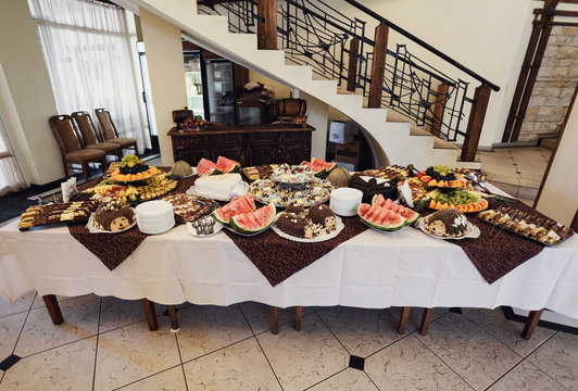 The buffet table with cakes and fruits