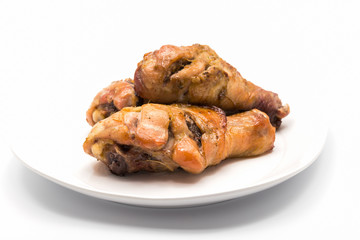 Grilled chicken drumsticks on white plate isolated on white background