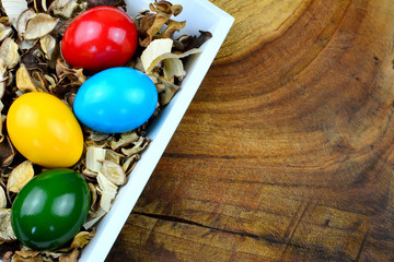 Oster Motiv - Bunte Ostereier in einem Potpourri auf einem Holztisch mit Textfreiraum