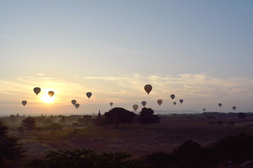 Sunrise with hot air balloons are flying over the pagodas plain of Bagan, Myanmar.