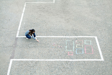 Girl draws chalk house / building