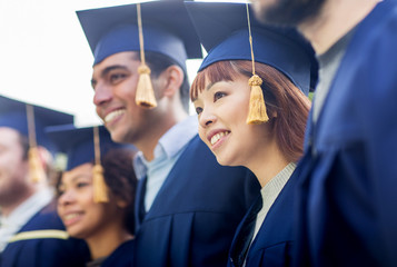 happy students or bachelors in mortar boards