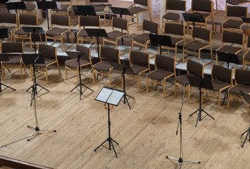 Empty stage with chairs, microphones and music stands before the