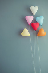 Multicolor balloons heart shape on blue wall background.