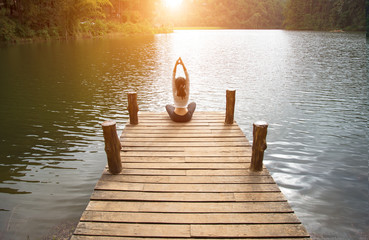 Woman do yoga outdoor. Woman exercising yoga at the nature background, select focus.