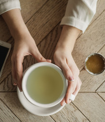woman drinking tea, holding cup