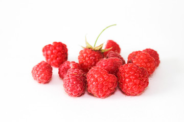 Heap of red ripe raspberry isolated on white