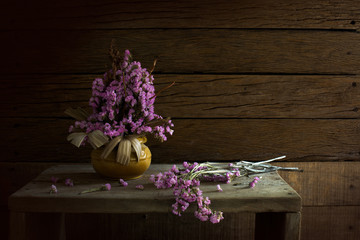 Vase with withered flowers on the old wooden chair and wooden table / still light image