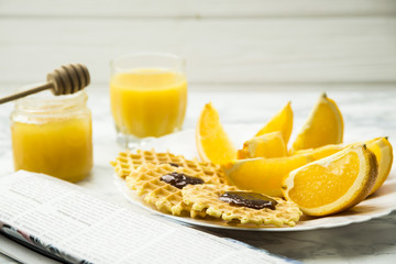 healthy breakfast at a marble table with orange juice. read a newspaper
