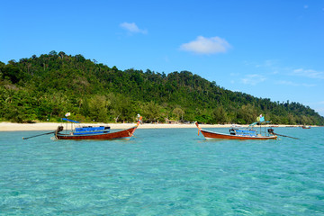 Fototapeta na wymiar Wooden boats with clear water in koh Ngai, Trang, Thailand
