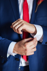 A man adjusts his cufflinks