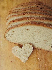 Foto auf Acrylglas Herzförmiges Stück Brot vor Vollbrot © melih2810