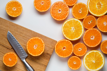 cut oranges and tangerines on a white background