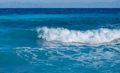 A wave breaks on the beach in the Aegean Sea on the island of Rhodes