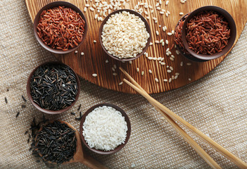 Different types of rice in small bowls, top view