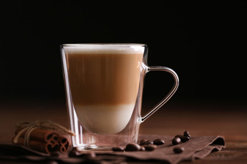 Cup of coffee and beans on black background