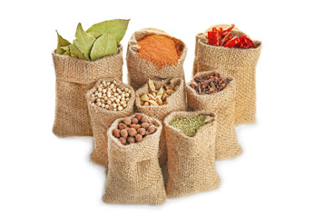 Spices in sacking bags on white background