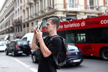 Man tourist on the streets of Rome with the Tablet