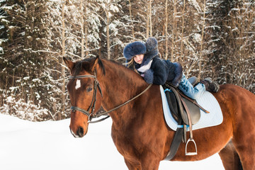 Small girl and horse in a winter