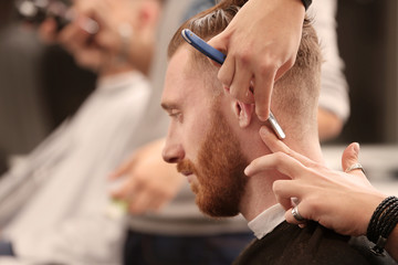 Barber making modern male hairstyle