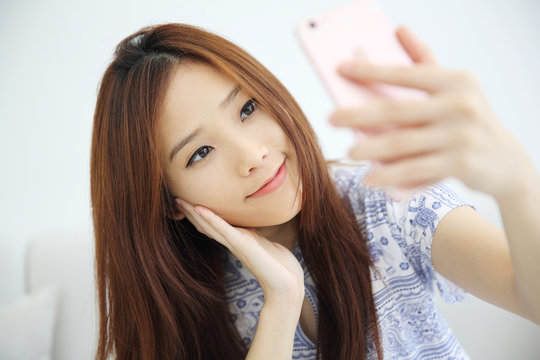 Young beautiful woman photo selfie in white tone