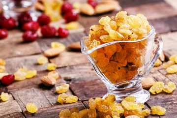 Sweet golden raisins, old wooden background, selective focus
