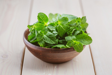 Green fresh mint om the wooden table, selective focus