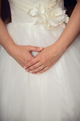 Bride hands on wedding dress