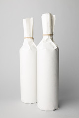 Two wine bottles are standing on gray background