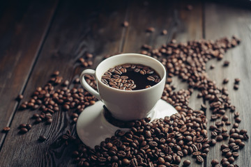 a cup of coffee on an inverted saucer and grains