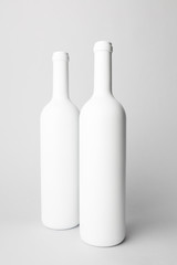 Two wine bottles are standing on gray background