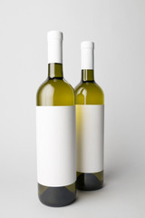Two wine bottles are standing on gray background