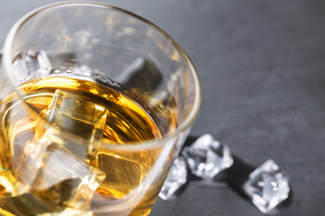 Detail of glass of whiskey and ice cubes