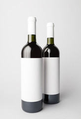 Two wine bottles are standing on gray background