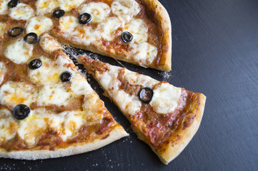 pizza Margarita on a black background, blank space on the right